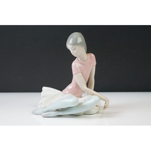 63 - Three Lladro Porcelain Figures to include a seated ballerina, girl holding lamb and an angel with fl... 