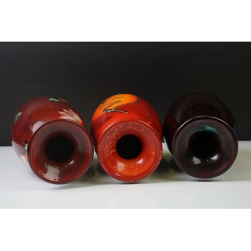 71 - Three Anita Harris Studio baluster vases to include an example with flame-like design on ox blood gr... 