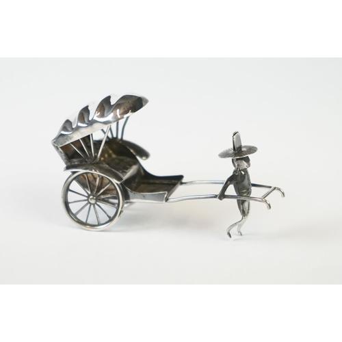 215 - A Chinese sterling silver ornament of a man pulling a rickshaw.