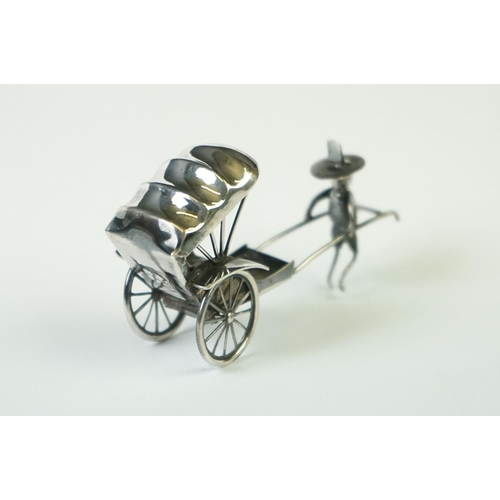 215 - A Chinese sterling silver ornament of a man pulling a rickshaw.