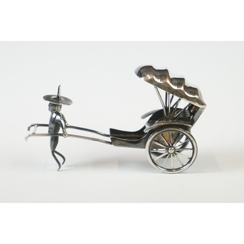 215 - A Chinese sterling silver ornament of a man pulling a rickshaw.