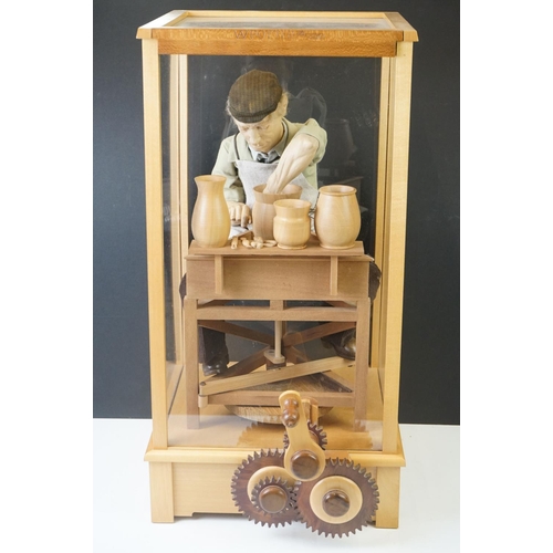 196 - Cased Mechanical Wooden Automaton of a Potter at his Wheel, the cased inscribed with a monogram, Pot... 