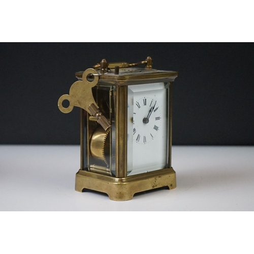 280 - A brass cased carriage clock with beveled glass panels and white enamel dial, complete with key.