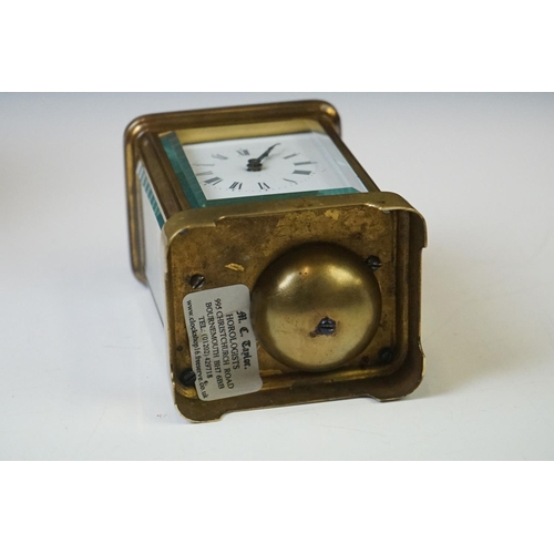 280 - A brass cased carriage clock with beveled glass panels and white enamel dial, complete with key.