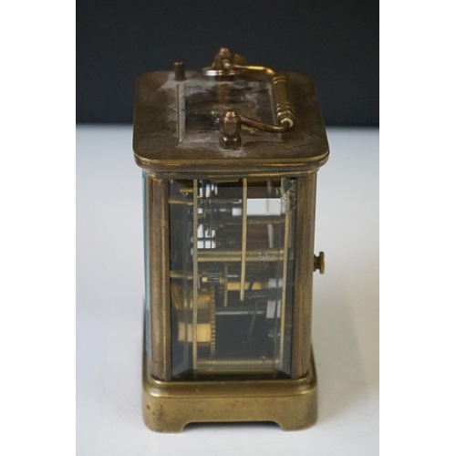 280 - A brass cased carriage clock with beveled glass panels and white enamel dial, complete with key.