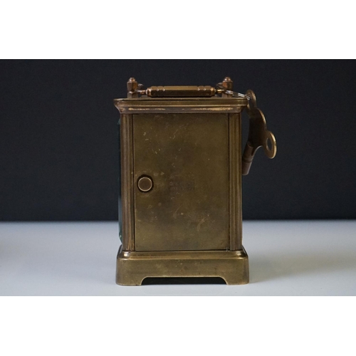 280 - A brass cased carriage clock with beveled glass panels and white enamel dial, complete with key.