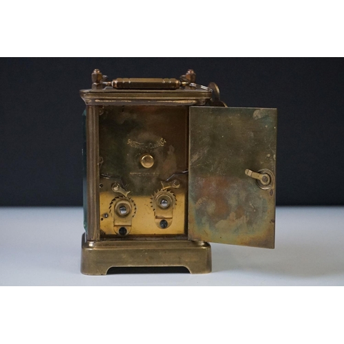 280 - A brass cased carriage clock with beveled glass panels and white enamel dial, complete with key.