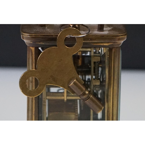 280 - A brass cased carriage clock with beveled glass panels and white enamel dial, complete with key.