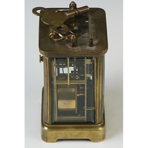 280 - A brass cased carriage clock with beveled glass panels and white enamel dial, complete with key.