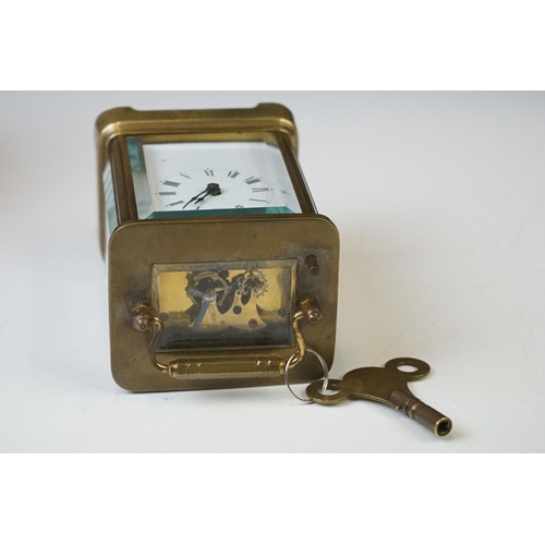 280 - A brass cased carriage clock with beveled glass panels and white enamel dial, complete with key.