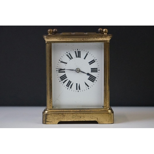 282 - A French carriage clock with bevelled glass panels and white enamel dial, complete with key.