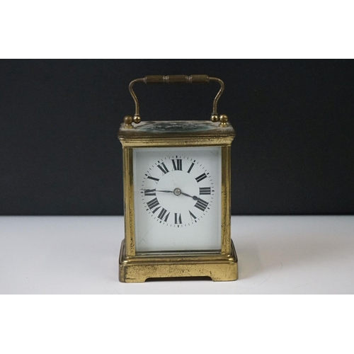 282 - A French carriage clock with bevelled glass panels and white enamel dial, complete with key.