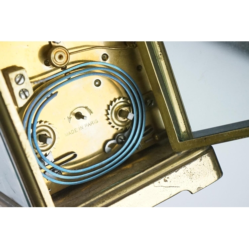 282 - A French carriage clock with bevelled glass panels and white enamel dial, complete with key.