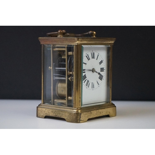 282 - A French carriage clock with bevelled glass panels and white enamel dial, complete with key.