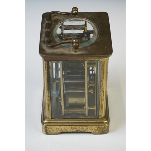 282 - A French carriage clock with bevelled glass panels and white enamel dial, complete with key.