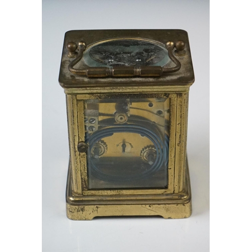 282 - A French carriage clock with bevelled glass panels and white enamel dial, complete with key.