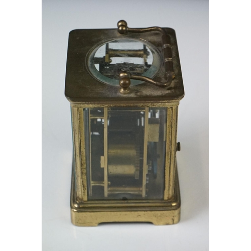 282 - A French carriage clock with bevelled glass panels and white enamel dial, complete with key.