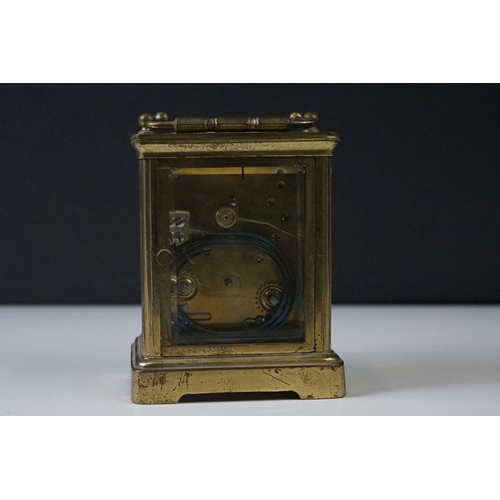 282 - A French carriage clock with bevelled glass panels and white enamel dial, complete with key.