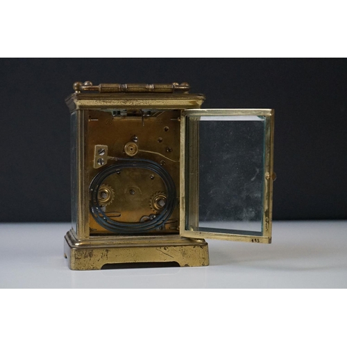 282 - A French carriage clock with bevelled glass panels and white enamel dial, complete with key.