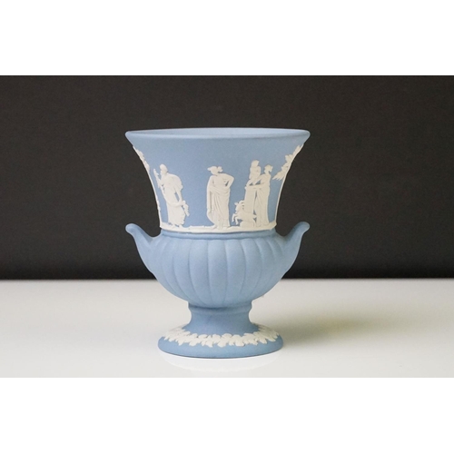 57 - Three pieces of Wedgwood Jasperware in pale blue to include a tapering vase (19cm high), urn-shaped ... 