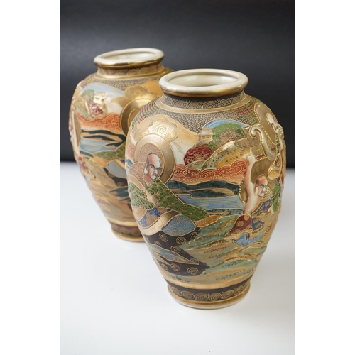 10 - Pair of 20th Century Japanese Satsuma vases of ovoid form, with relief moulded seated figures and be... 