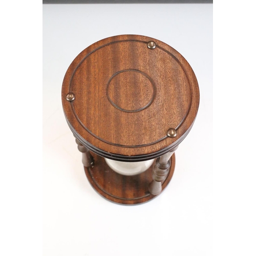 160 - Large Glass Sand Timer held on a Mahogany Circular Frame with turned supports, 24cm high