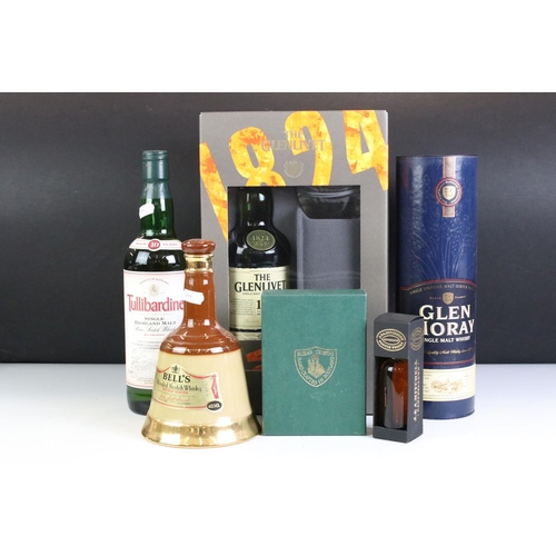 425 - A small collection of bottled alcohol to include a Glenlivet gift set and a Wade Bells Whisky bottle