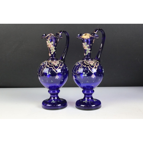 73 - Pair of Murano Blue Glass Ewers with gilt and enamel floral decoration, 21cm high together with Pair... 