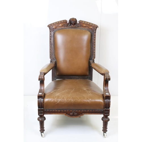 585 - Victorian Carved Oak Open Armchair, the top rail carved with a face mask, raised on castors, 66cm wi... 