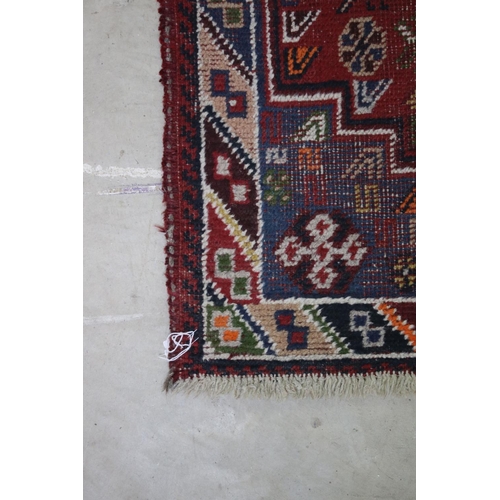 558 - Iranian Wool Red Ground Rug with stylised pattern of birds and flowers within a border, 105cm x 67cm