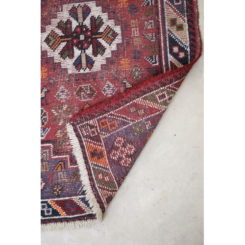 558 - Iranian Wool Red Ground Rug with stylised pattern of birds and flowers within a border, 105cm x 67cm