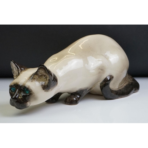 8 - Winstanley pottery figure of a crouching Siamese cat with blue glass eyes, signed to the base and nu... 