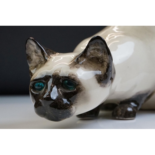 8 - Winstanley pottery figure of a crouching Siamese cat with blue glass eyes, signed to the base and nu... 