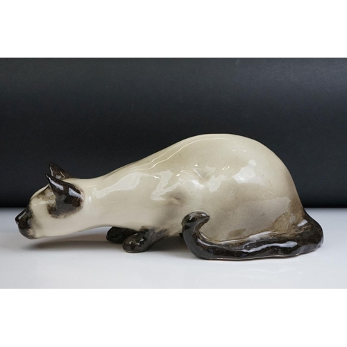 8 - Winstanley pottery figure of a crouching Siamese cat with blue glass eyes, signed to the base and nu... 