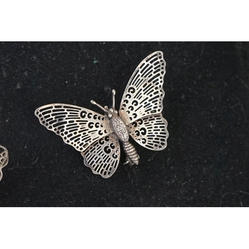 205 - A small collection of brooches to include filigree Butterflies together with two display stands.