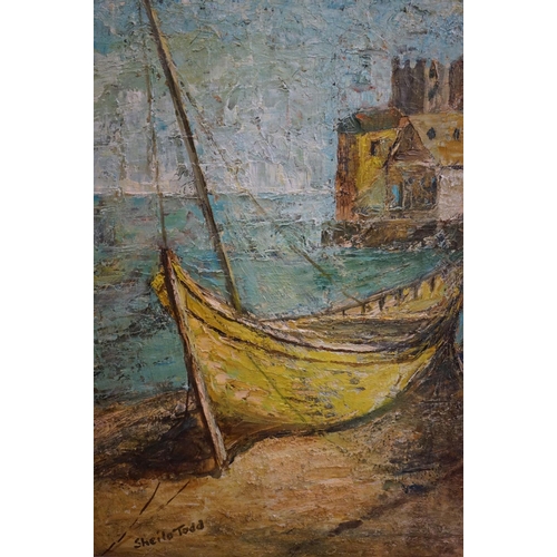 479 - Sheila Todd oil on board, beached boats by a fishing village, approx. 45cm x 75cm