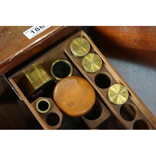 186 - A mahogany cased microscope by J.B. Dancer of Manchester with extra lenses, slides...etc.