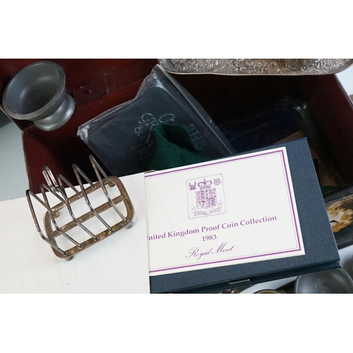 297 - A box of mixed collectables to include coins, silver plated toast racks, Royal Mint coin sets, cutle... 