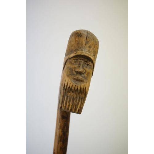 392 - A vintage hand carved walking stick with figural head handle.