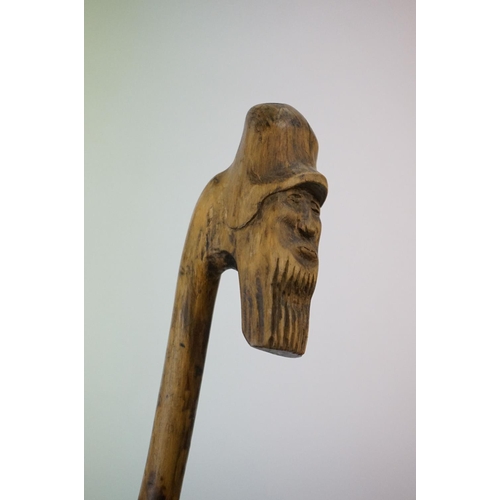 392 - A vintage hand carved walking stick with figural head handle.