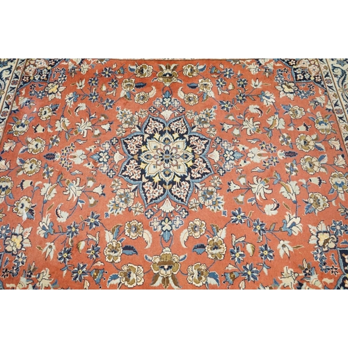 557 - Pink and Cream Ground Rug with floral pattern within a border, 256cm x 200cm