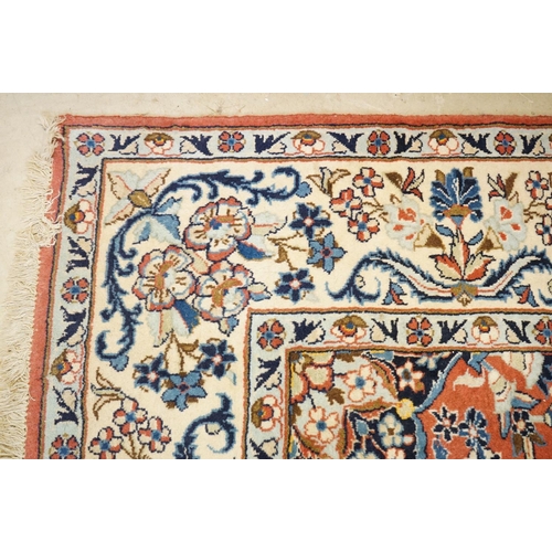 557 - Pink and Cream Ground Rug with floral pattern within a border, 256cm x 200cm