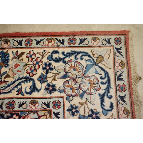 557 - Pink and Cream Ground Rug with floral pattern within a border, 256cm x 200cm