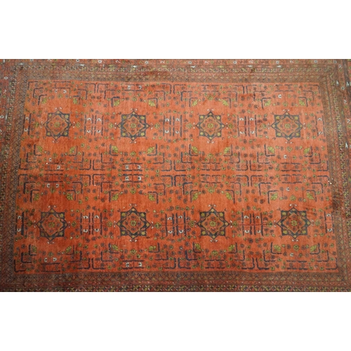 563 - Eastern Wool Red ground Rug with floral and geometric design within a border, 215cm x 280cm