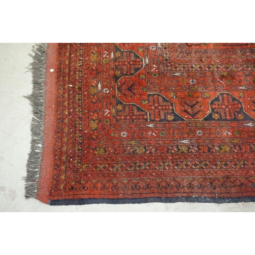 563 - Eastern Wool Red ground Rug with floral and geometric design within a border, 215cm x 280cm