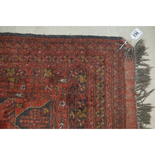 563 - Eastern Wool Red ground Rug with floral and geometric design within a border, 215cm x 280cm