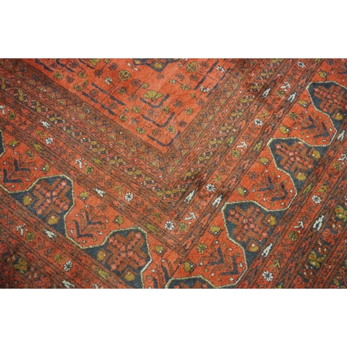 563 - Eastern Wool Red ground Rug with floral and geometric design within a border, 215cm x 280cm