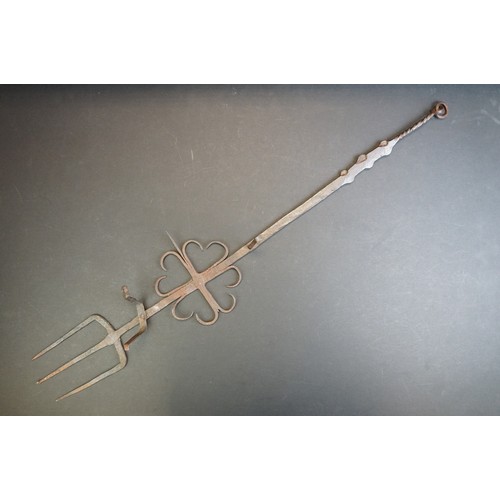 412 - A small group of brass trivets and fire side tools including a 17th century downhearth toasting fork... 