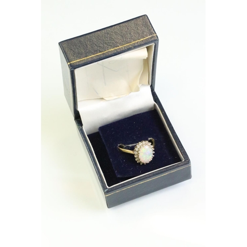 35 - Opal and diamond 18ct yellow and white gold set cluster ring, the precious white opal displaying vio... 