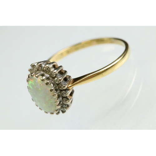 35 - Opal and diamond 18ct yellow and white gold set cluster ring, the precious white opal displaying vio... 